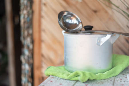Casserole and ladle on the rural table background.の写真素材