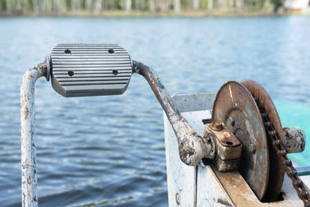 Old catamaran rusty gear on a blue water pond background.の写真素材