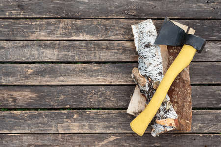 Ax and chopped birch log on wooden table background with copy space.の写真素材