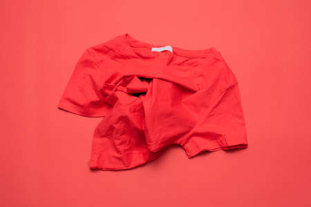 A red t-shirt on a red flat lay background.の写真素材