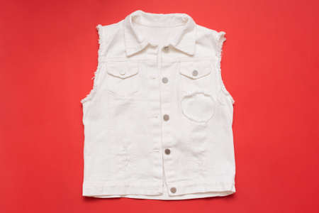White denim jeans vest on a red background.の写真素材