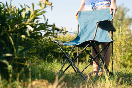 Young woman is standing in the garden yard and is sunbathing.の写真素材