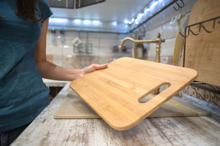 Woman is choosing a new cutting board for kitchen close up.の写真素材