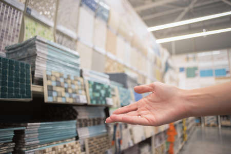 Woman is choosing a new tile for home in a construction store.の写真素材