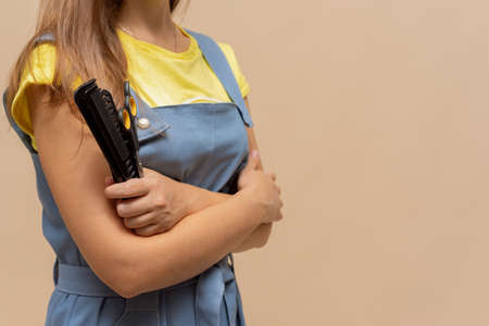 Hairdresser with scissors and hairbrush in hands on light background with copy space.の写真素材