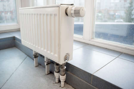 White modern heating radiator on the window background.