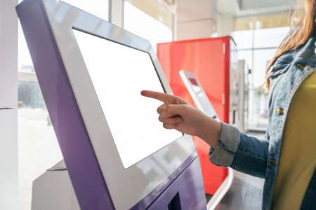 Woman is touching a blank screen of interactive terminal close up.の写真素材