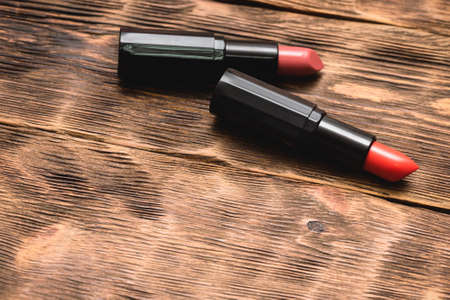 Two lipstick on the brown wooden table background with copy space.の写真素材