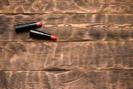 Two lipstick on the brown wooden table background with copy space.の写真素材