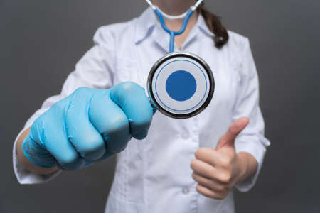 Doctor with stethoscope in the hand is showing a thumbs up gesture close up.の写真素材