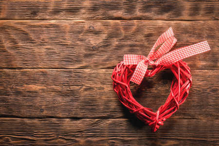 Red heart shape toy on the wooden table flat lay background with copy space.の写真素材