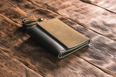 Female wallet on the brown table background.