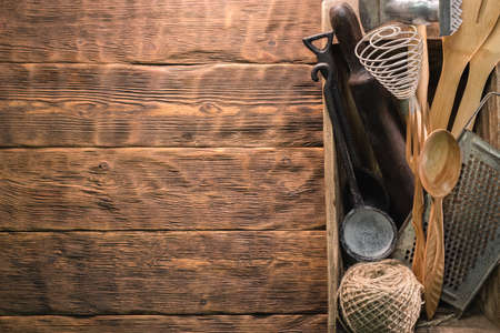 Rural kitchen utensils on the wooden table background with copy space.