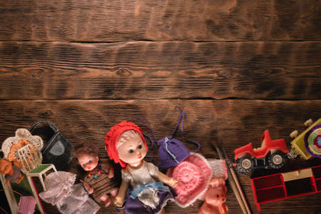 Old retro girl children toys on the brown wooden table background.の写真素材
