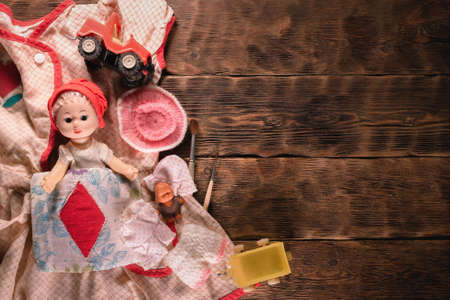 Old retro girl children toys on the brown wooden table background.