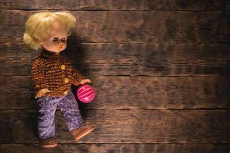 Old retro girl children toys on the brown wooden table background.の写真素材