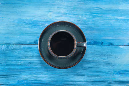 Black coffee in a cup on the blue wooden table background.の写真素材