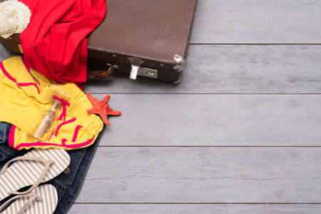 Old suitcase and clothing on the wooden floor background with copy space.の写真素材
