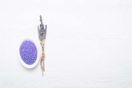 Lavender bath solt in the small bowl and dried lavender flowers on the white background.の写真素材