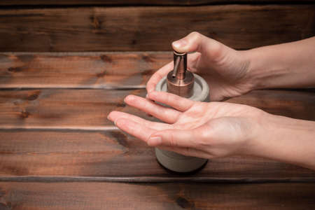 Soap dispenser bottle in female hands. Wash hands.の写真素材