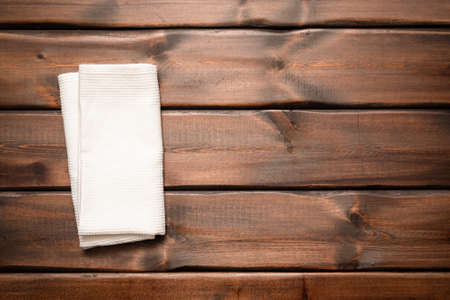 White towel on the brown wooden table background with copy space top view.の写真素材