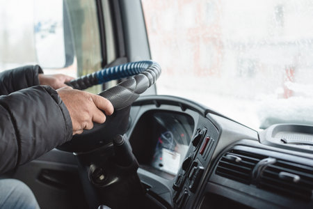 Truck driver hands on the steering wheel close up background.の写真素材