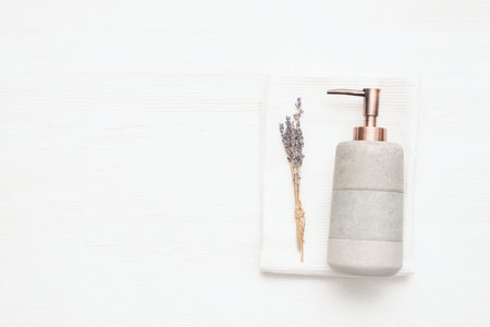 Soap dispenser, towel and lavender flowers branch.の写真素材