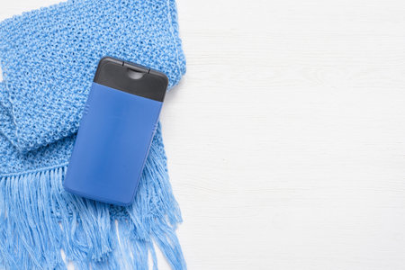 Shower gel and knitted scarf on white wooden table background.の写真素材