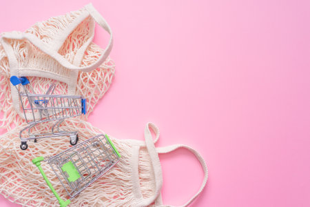 String bag and shopping cart on the pink background.の写真素材