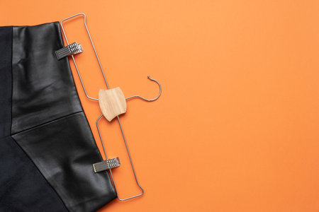 Black skirt on the hanger on the orange flat lay background.の写真素材