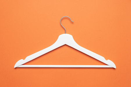 White clothes hanger on the orange flat lay background.の写真素材
