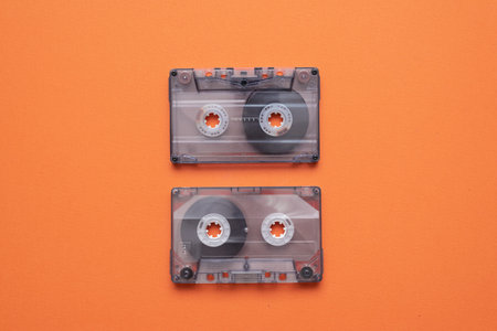 Old retro stereo cassette on the orange flat lay background.