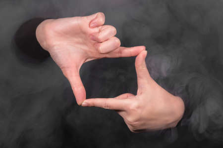 Woman is showing a frame by her hands close up.の写真素材