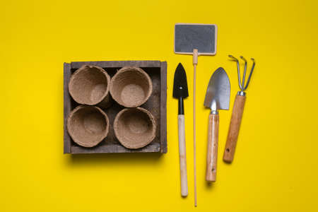 Garden tools and empty flower pots on the yellow flat lay background. Planting abstract background.の写真素材