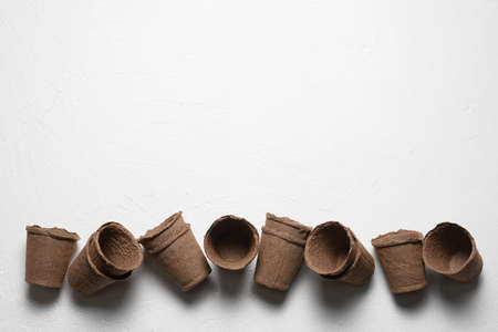 Brown flower pots on the white table background. Gardening concept background.