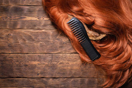 Hairdressing salon concept background. Redhead women wig and combs on the hairdresser table flat lay background with copy space.の写真素材