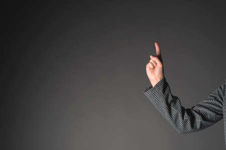 Woman hand is showing up by index finger on the copy space.の写真素材