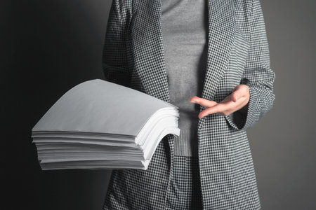 Woman a secretary is showing a heap of documents in her hands.の写真素材