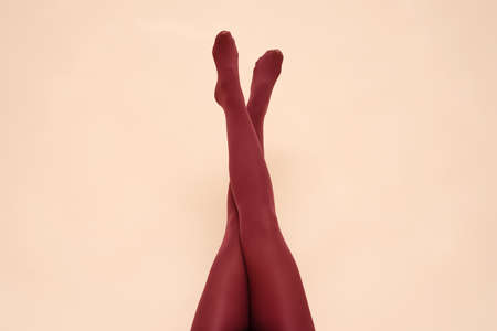 Woman raised up legs in the red stockings on the light background.の写真素材