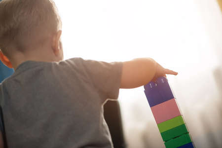 A little boy is playing with a children building kit close up.の写真素材
