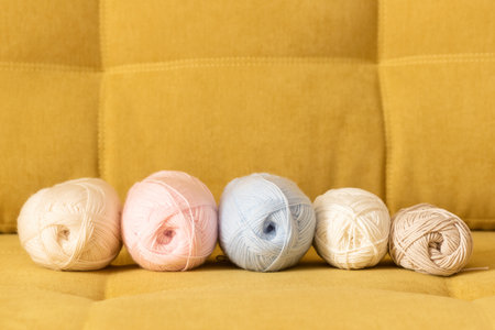 Balls of woolen threads on the sofa. Knitting background.