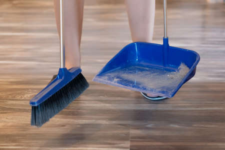 Broom brush and dustpan on the floor. Home cleaning.の写真素材