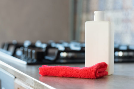 Detergent bottle and rag on the kitchen stove background.の写真素材