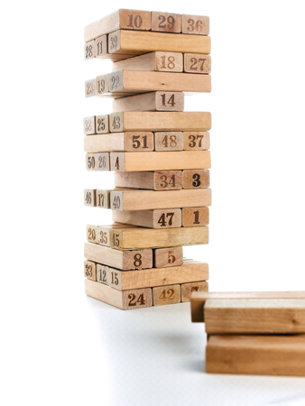 Blocks of game isolated on white background. Vertical tower whole and in game. Wooden blocks in stack with figures digit on body.の写真素材