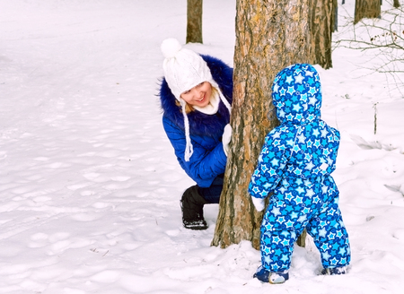 Happy and joyful mother and child on walk, play in the winter forest. Pine forest of Chelyabinsk...