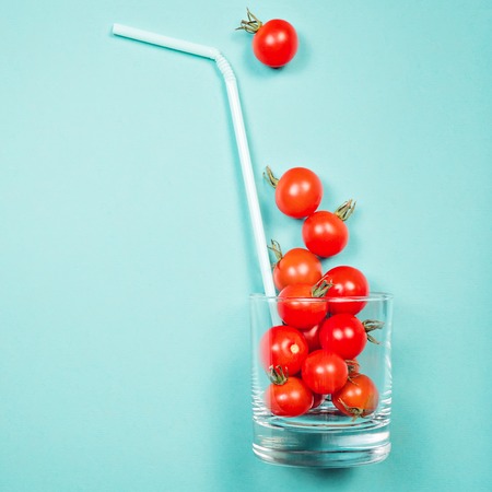 Tomato juice or smoothie, recipe ingredient healthy eating, healthy drink concept, organic detox vegetable, cherry tomato in drink glass with straw. Flat lay with copy space, multi color background.の写真素材