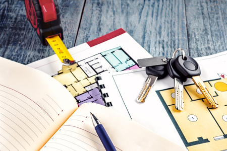 Linking new key on project plan of apartment house Concept new residence house warming Buying...