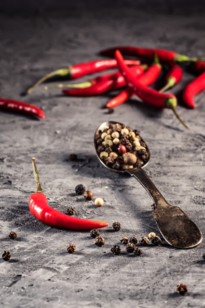 Red hot chilli pepper paprika in and peppers seed ball on stone table Ingredient for Mexican cooking Trendy toned image in minimal rustic styleの写真素材
