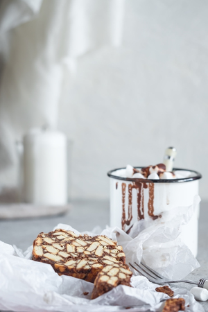 Pieces of chocolate cake from cookies and cocoa with marshmallow on bakery paper High key Still life food style Hugge scandinavian nordic with candleの写真素材