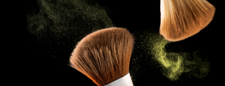 Cosmetic makeup brushes on  black background flash explosion splash powder shadow blushの写真素材